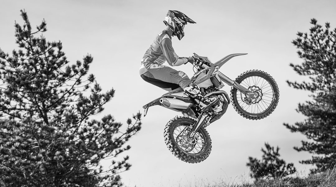 Piloto en acción conduciendo una Beta 4T 350 en terreno de montaña.