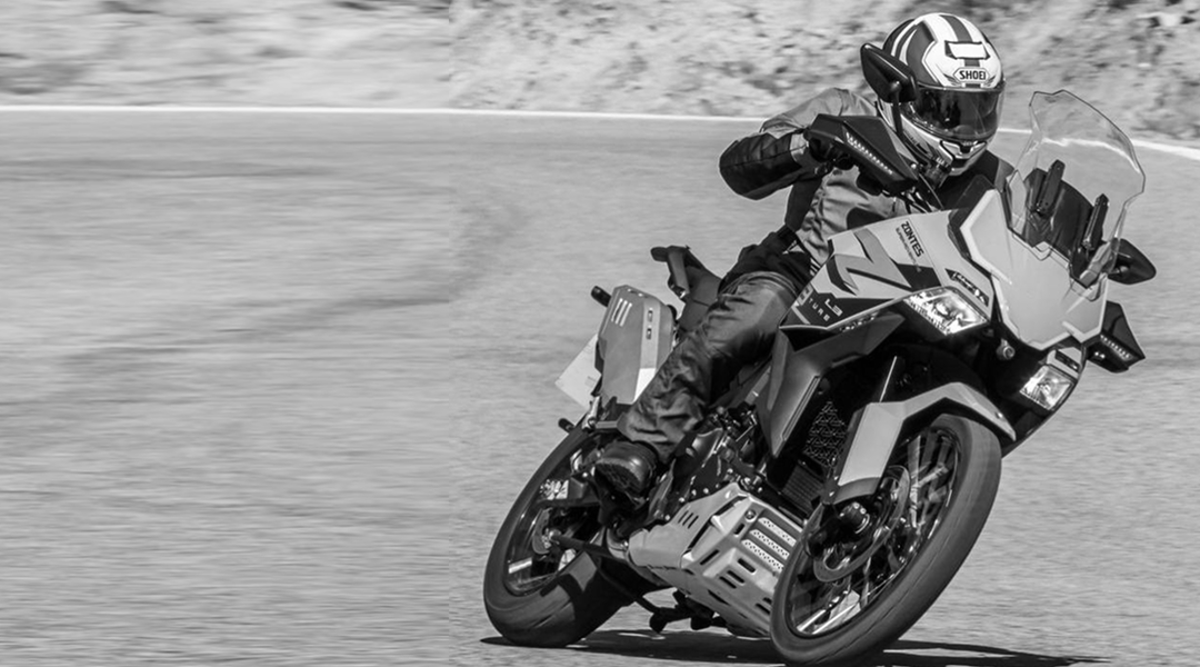 Moto Zontes 703F Adventure en acción sobre camino de tierra.